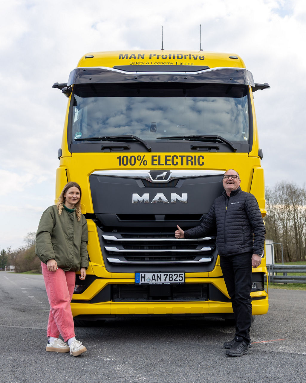 Jana Forkel und Michael Noll vor dem gelben MAN TGX von MAN ProfiDrive